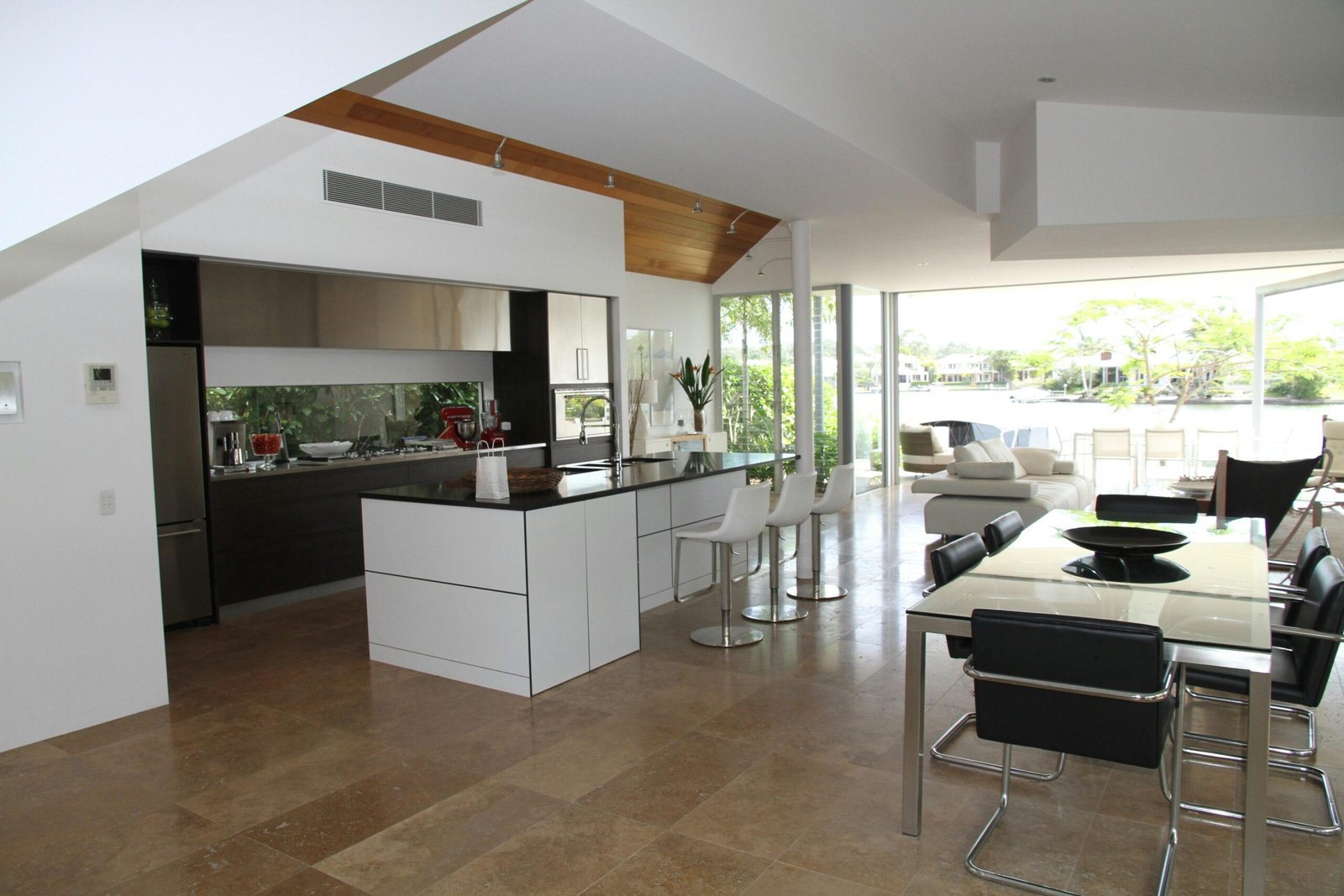 Spacious modern kitchen and living room with open design overlooking a scenic outdoor view.